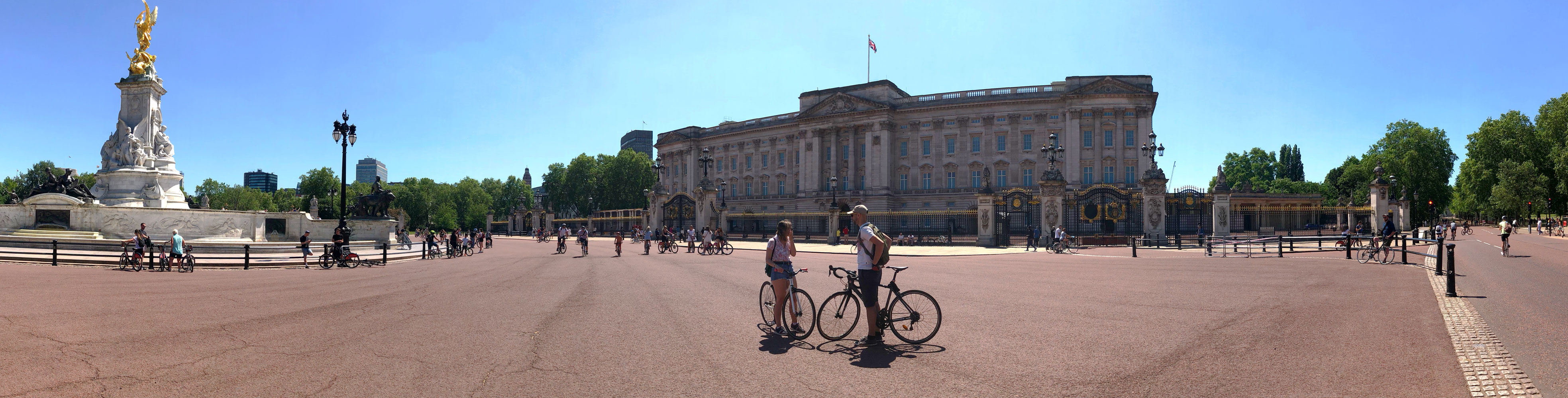 Numerous cyclists outside Buckingham Palace on a sunny day